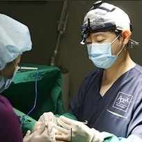 수술방에서 루페와 마스크를 착용한 의료진이 수술을 집도하는 모습