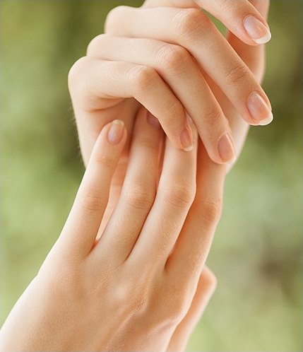 한 손이 다른 손등을 부드럽게 감싸 쥔 여성의 두 손 클로즈업