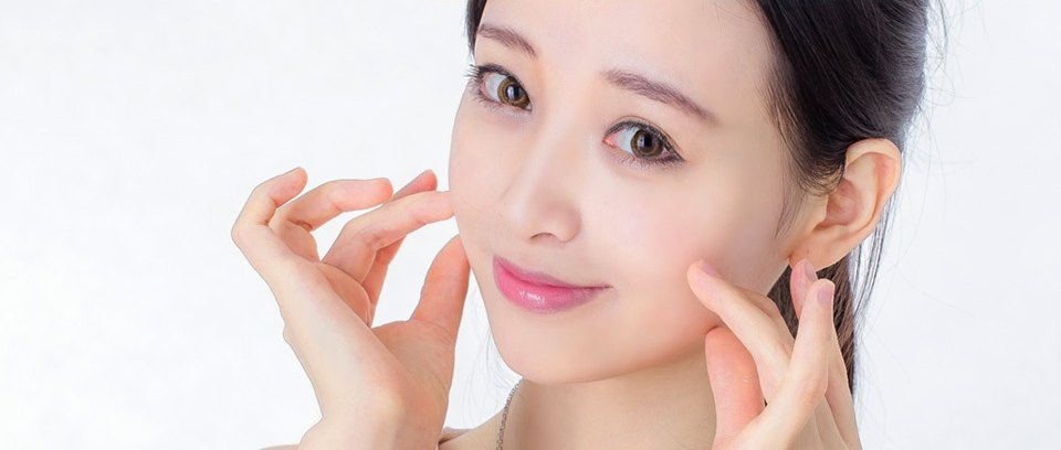 양손 손끝을 볼과 턱선에 대고 미소 짓는 여성의 클로즈업 — 칼귀 예방과 흉터 최소화를 상징하는 이미지